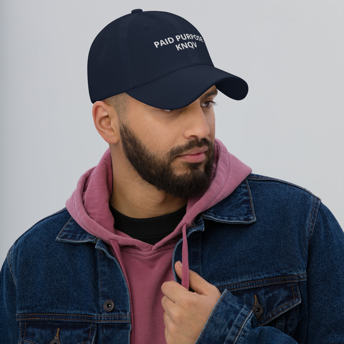 Male model wearing the navy KNQV PAID PURPOSE embroidered dad cap