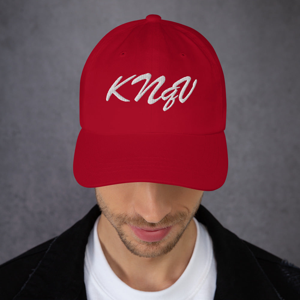 Male model wearing KNQV Bordeaux Club cranberry embroidered dad hat — Printful digital mockup