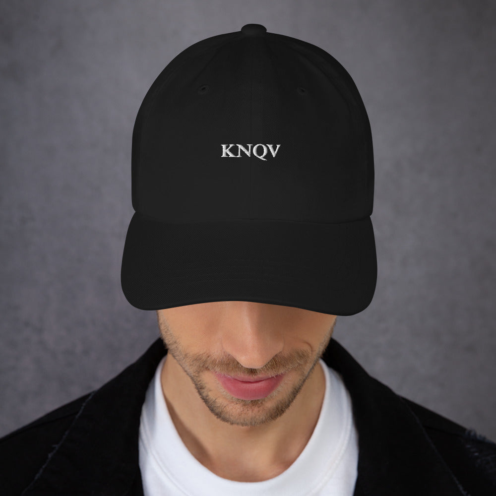 Printful male-model mockup — KNQV Midnight Monogram cap front embroidery