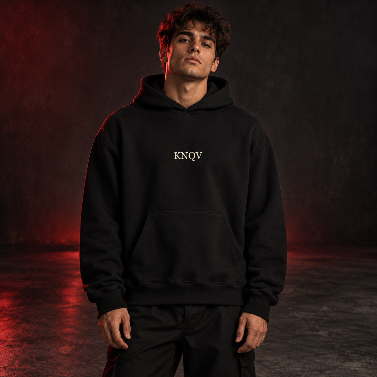 KNQV Music Capsule hoodie — AI-generated red-studio model-front mockup