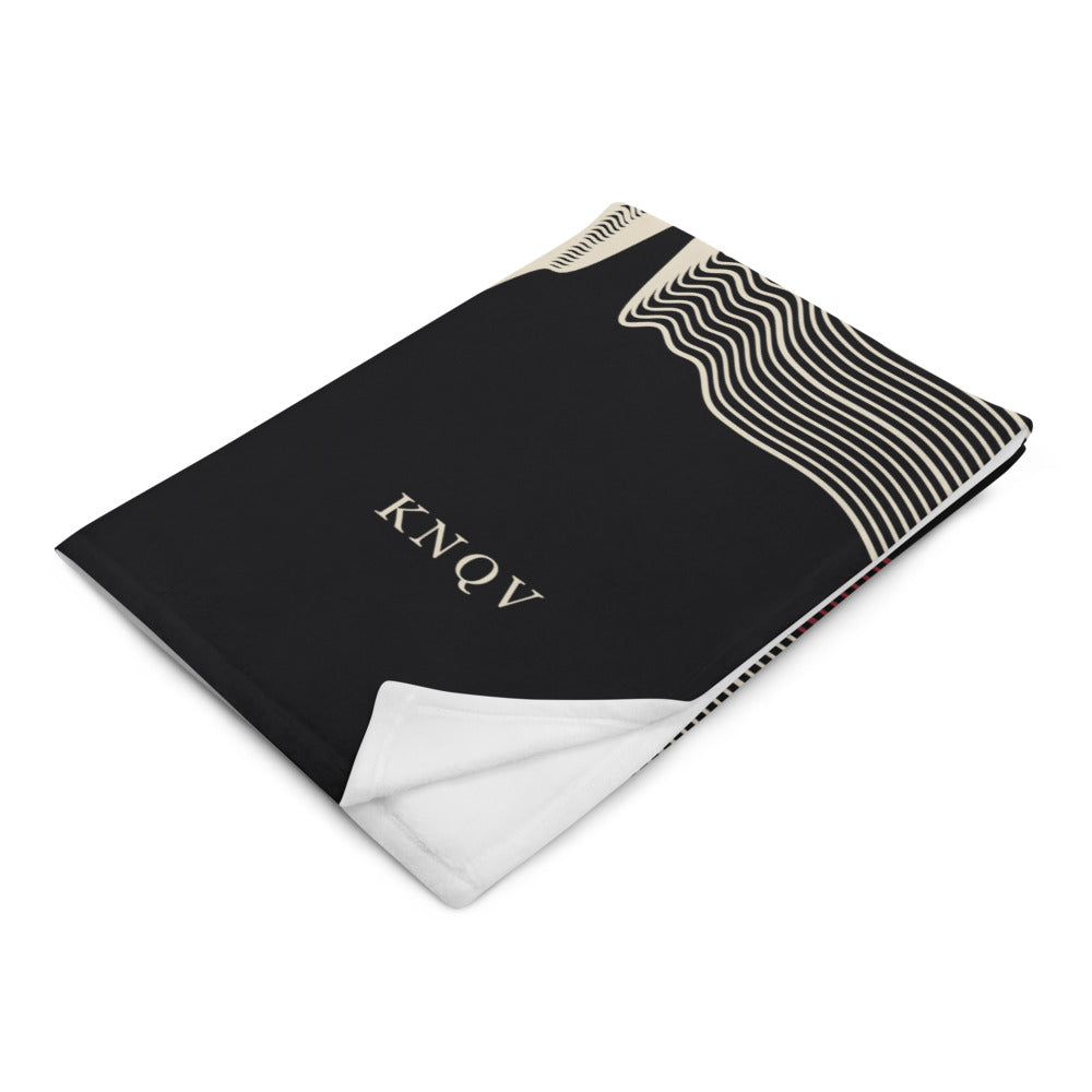 Folded KNQV Frequency Throw Blanket with cream KNQV branding; digital supplier mockup